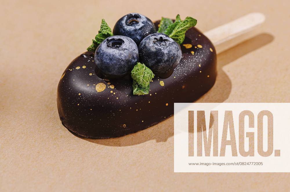 Foodfotografie, Handwerklich hergestellte Eisriegel mit frischen Blaubeeren und Schokolade auf einem warmen, neutralen Hintergrund Food, Artisanal ice cream bars with fresh blueberries and chocolate on a warm neutral background