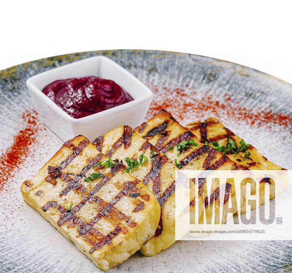 Foodfotografie, Perfekt gegrillte Halloumi Käsescheiben, serviert mit einer lebhaften Beerensauce auf einem eleganten Teller Food, Slices of halloumi cheese, grilled to perfection and served with a vibrant berry sauce on an elegant plate