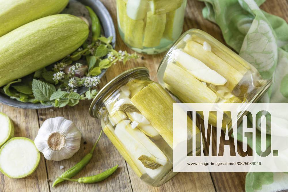 Gesunde hausgemachte fermentierte Lebensmittel. Eingelegte Zucchini mit Minze, eingemacht in Glasgefäß Hauswirtschaft, Konservierung der Herbsternte Healthy homemade fermented food. Pickled zucchini with mint preserved canned in glass jar. Home economics, autumn harvest preservation