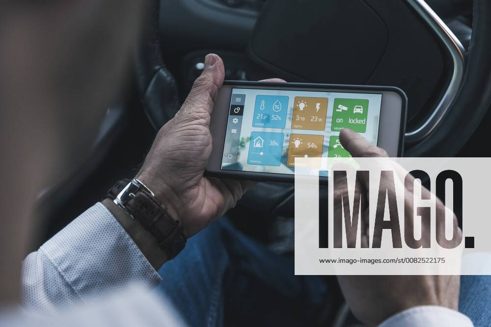 Man in car adjusting devices at home via smartphone model released Symbolfoto property released UUF12651