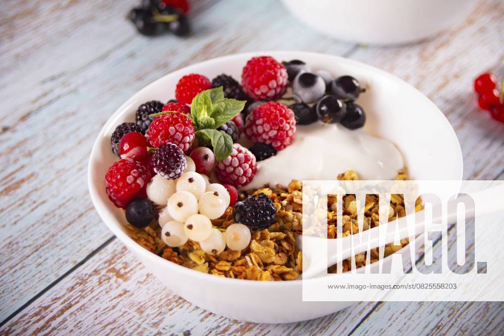 Granola, Müsli mit Joghurt oder Milch und frischen Beeren. Gesundes Frühstückskonzept Granola, muesli cereals with yogurt or milk and fresh berries. Healthy breakfast concept