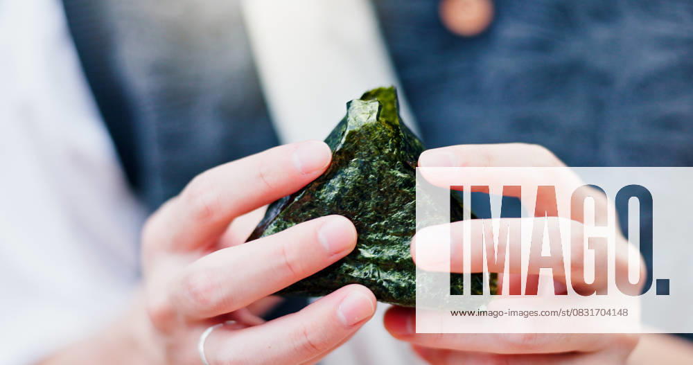 IMAGO Creative, Food, Japan, Onigiri Hands, person and rice ball in Japan for food, traditional snack or fresh natural seaweed triangle for culture. Onigiri, closeup or eating meal for organic lunch, hungry or healthy diet for nutrition Hands, person and rice ball in Japan for food, traditional snack or fresh natural seaweed triangle for culture. Onigiri, closeup or eating meal for organic lunch, hungry or healthy diet for nutrition., model released, , 63250996.jpg RECORD DATE NOT STATED