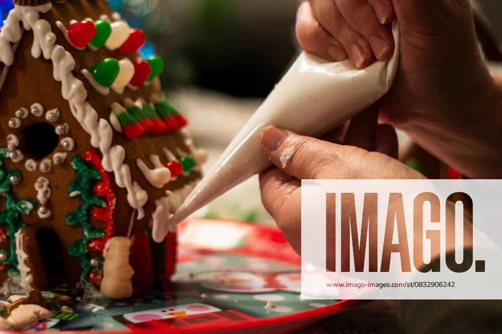 IMAGO Creative, Weihnachten, Food, Backen, Lebkuchen Icing being piped onto a gingerbread house corner Kelowna, British Columbia, Canada R_PESF250905-1820705-01