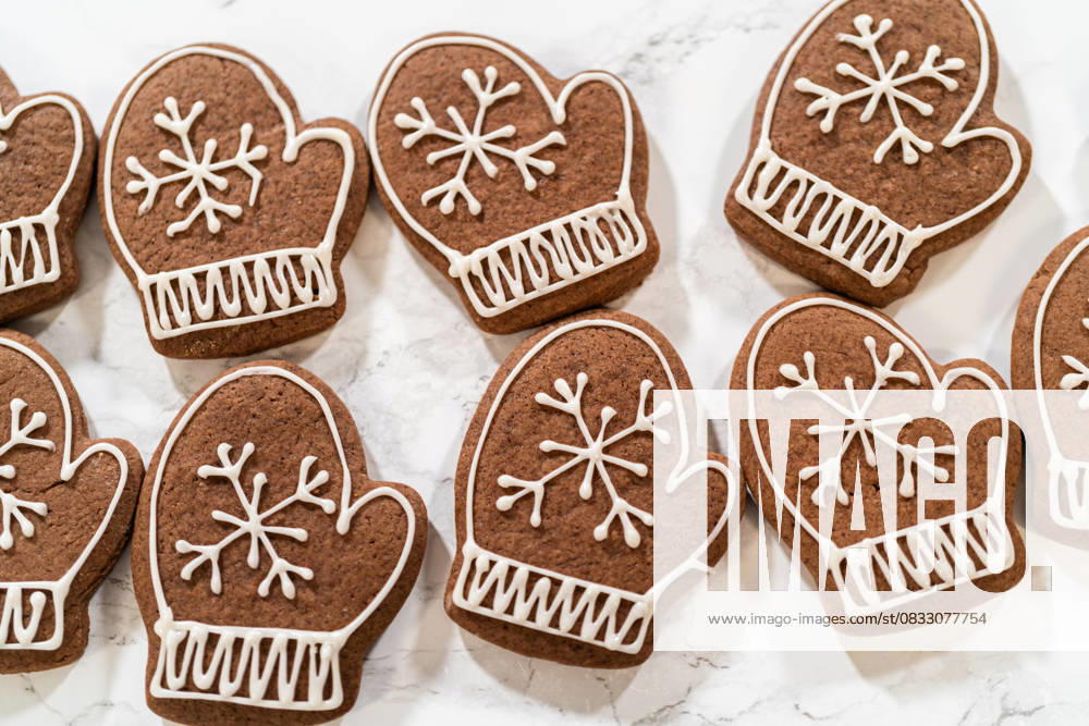 IMAGO Creative, Weihnachten, Food, Backen, Lebkuchen Beautifully Decorated Mitten Cookies with Royal Icing Designs Close-up of beautifully decorated mitten-shaped gingerbread cookies featuring intricate white royal icing designs, arranged on a marble surface., 94616066.jpg RECORD DATE NOT STATED