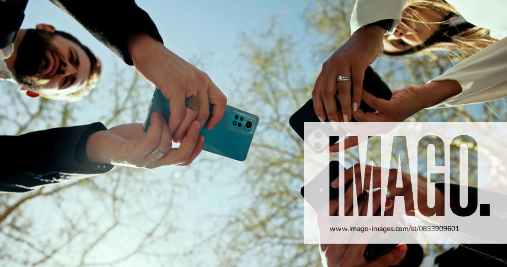 Business people, hands and phone in circle outdoor for global connection, team chat and b2b networking. Low angle, employees and smartphone at park for data sharing, online news and corporate website Business people, hands and phone in circle outdoor for global connection, team chat and b2b networking. Low angle, employees and smartphone at park for data sharing, online news and corporate website., model released, , 95610390.jpg RECORD DATE NOT STATED