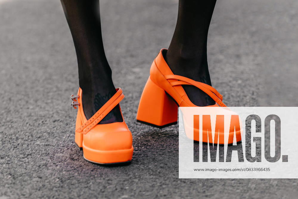 Milan, Italy - February, 23, 2022: woman wears orange high heel shoes Milan, Italy - February, 23, 2022: woman wears orange high heel shoes, street style details, 96472620