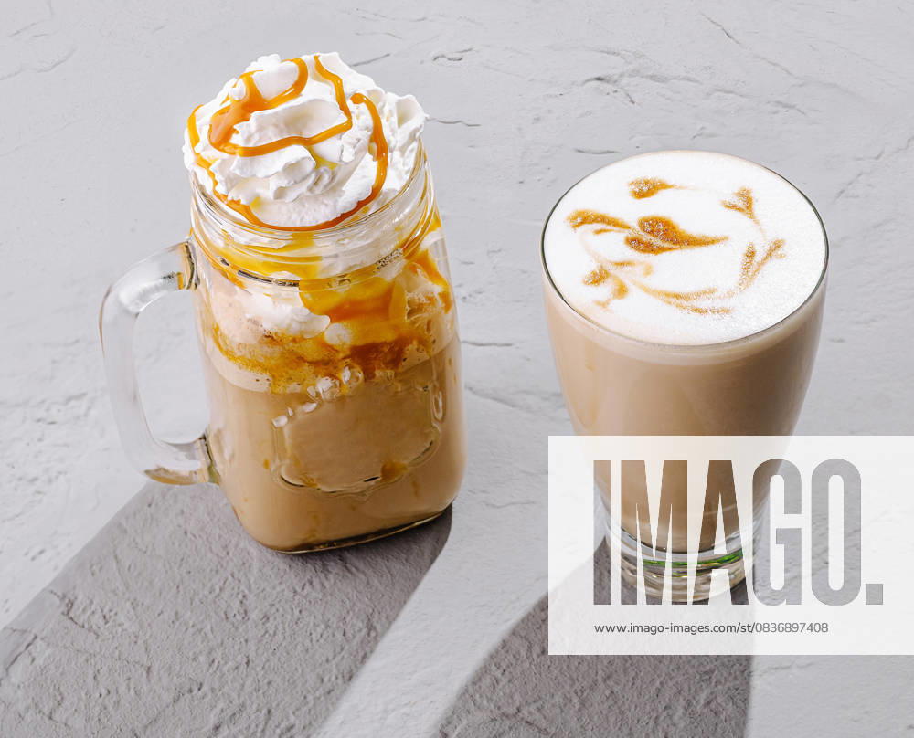 IMAGO Creative, Food, Trend, Iced Coffee Zwei Kaffeegetränke werden auf einer strukturierten Oberfläche präsentiert Two coffee beverages are presented on a textured surface. One drink is in a jar with whipped cream and caramel drizzle, while the other is a frothy latte in a tall glass, both inviting and refreshing. (License=RF)