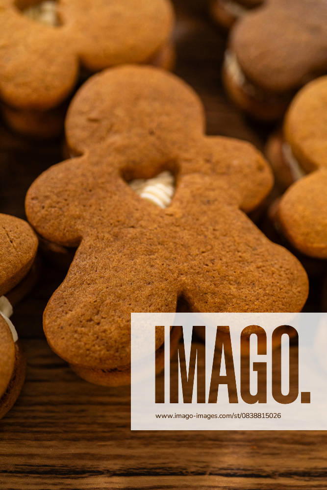 IMAGO Creative, Weihnachten, Food, Backen, Lebkuchen Making Festive Gingerbread Sandwiches on Rustic Wooden Table Making gingerbread man cookie sandwiches filled with eggnog buttercream, arrayed on a rustic wooden table, ideal for heartfelt Christmas gifting., 60765476.jpg RECORD DATE NOT STATED