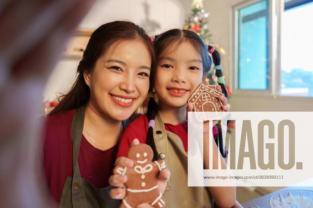 IMAGO Creative, Weihnachten, Food, Backen, Lebkuchen Festliche Leckereien. Mutter und Tochter zeigen stolz ihre verzierten Lebkuchen. A mother and daughter show off their beautifully decorated gingerbread cookies, celebrating the joy of baking during the holidays. (License=RF) ,model released, Symbolfoto