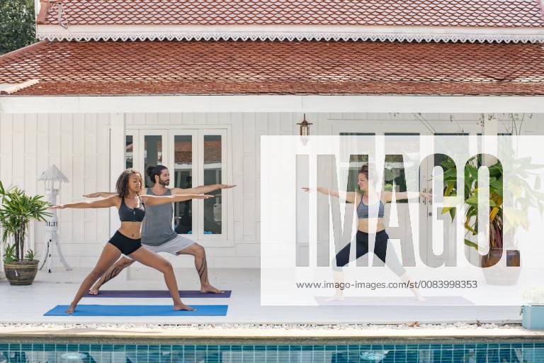Two women and a man practicing yoga on terrace model released Symbolfoto property released MOMF00427