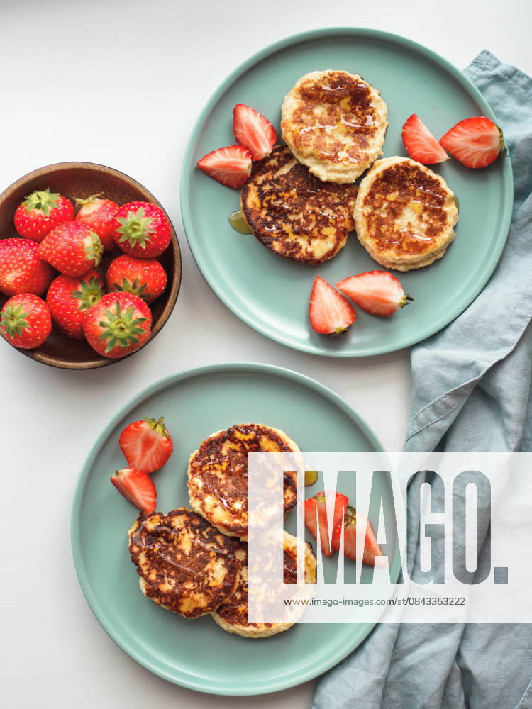 IMAGO Creative, Food, High Protein Frühstück Cottage cheese pancakes, syrniki, ricotta fritters Sweet cheese pancakes on plate served strawberries. Cottage cheese pancakes, syrniki, ricotta fritters, curd fritters. Top view or flat lay. Vertical., 61673528.jpg RECORD DATE NOT STATED