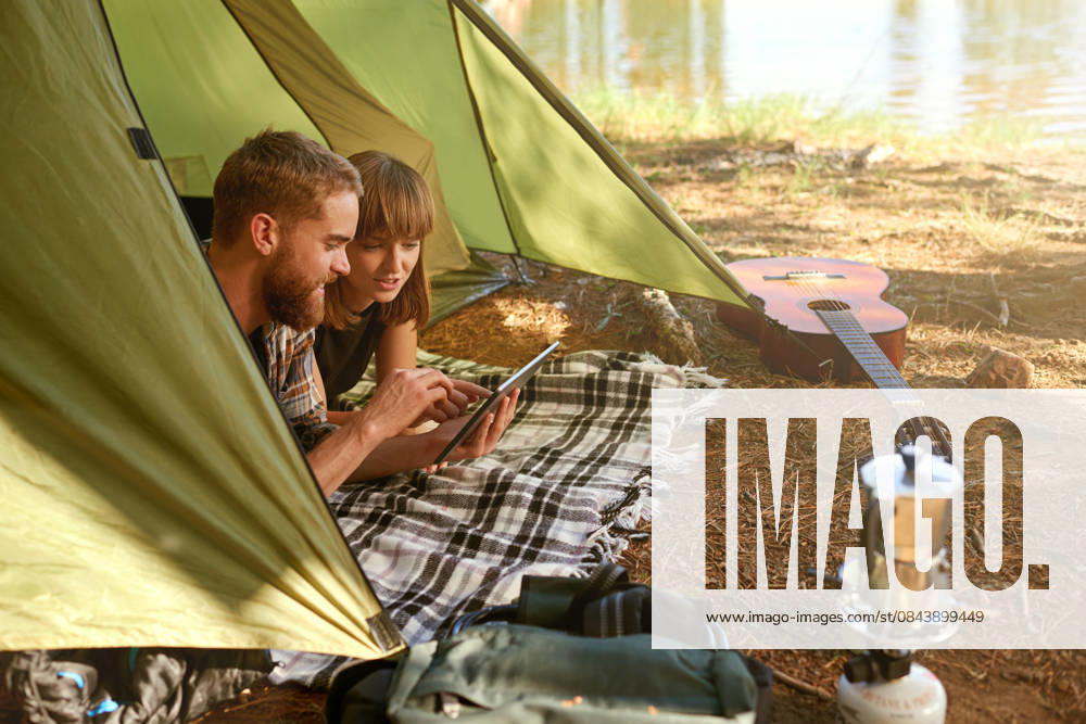 Couple, rest and tablet in tent for camping with communication, streaming online and bonding together. Smile, people and love with digital for entertainment, social media and travel vacation of date Couple, rest and tablet in tent for camping with communication, streaming online and bonding together. Smile, people and love with digital for entertainment, social media and travel vacation of date., model released, , 62974574.jpg RECORD DATE NOT STATED