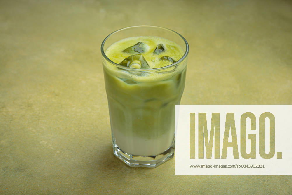 Iced matcha latte resting on a green background table in a glass Refreshing iced matcha latte, combining the earthy notes of matcha with the creamy texture of milk, served in a clear glass on a green surface, 63100542.jpg RECORD DATE NOT STATED