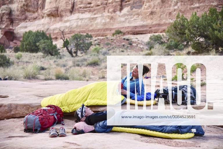 Side view of two women in sleeping bags while camping in Canyonlands National Park, Moab, Utah, USA, Moab UT USA HAMA001421 model released Symbolfoto