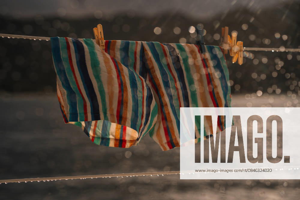 IMAGO Creative, Jahreszeit Sommer, Regen, Sommerregen Striped Men?s Swim Shorts Hanging on Catamaran Rail in Rain Victoria, Mont Fleuri, Seychelles CR_NMDM260127-1951716-01