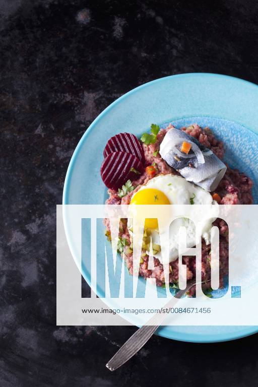 Plate of Labskaus with potatoes, rollmops, pickled gherkin, beetroot and fried egg CSF29199