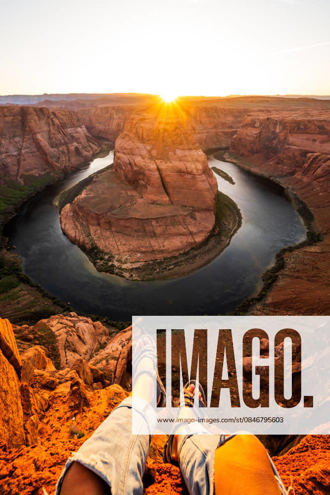 Dangling feet over Horseshoe Bend cliff at sunset Page, Arizona, United States CR_WLCB260128A-1952872-01 ,model released, Symbolfoto