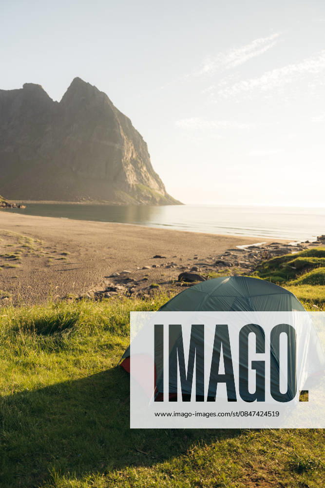 MR_ID32524_23616_IoritzLopez.jpg, MR_ID32524_23617_ArgineSatrustegui.jpg A serene camping scene in the Lofoten Islands, Northern Norway, capturing a tent by the beach under the summer midnight sun, perfect for trekking Model Released IoritzLopez_ID32524_1108263_045