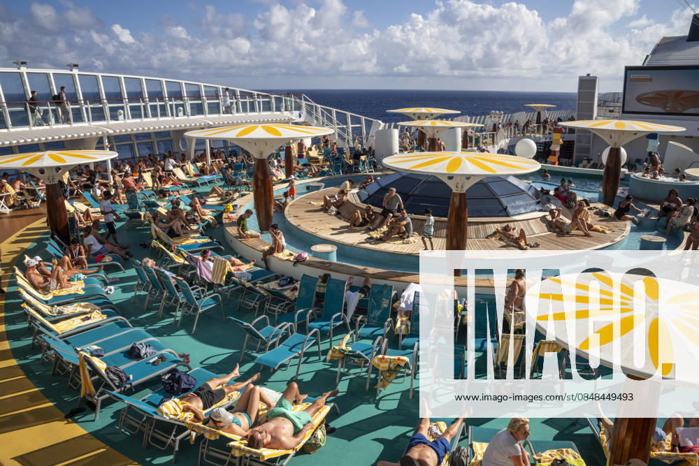 Relaxing on deck on the high seas Passengers on an AIDAblu cruise ship enjoy the voyage through the Caribbean St John s Antigua and Barbuda on the sun deck