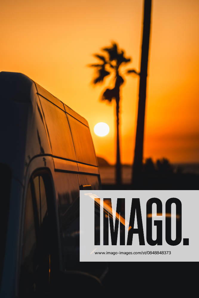 Sunset view with camper van in Galicia, Spain A tranquil evening in Galicia, Spain, with a camper van parked by the beach. The golden sunset illuminates the sky, creating a serene silhouette of palm trees and ocean waves. Model Released AlvaroMontero_ID33214_1131240_006