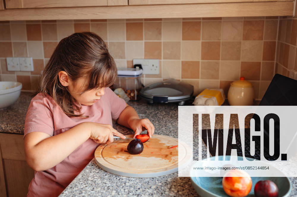 IMAGO Creative, Jahreszeit Sommer, Food, Pflaume Child girl cutting fruit on board, healthy eating. Corby, England, United Kingdom CR_JNDO260328-1931362-01 ,model released, Symbolfoto