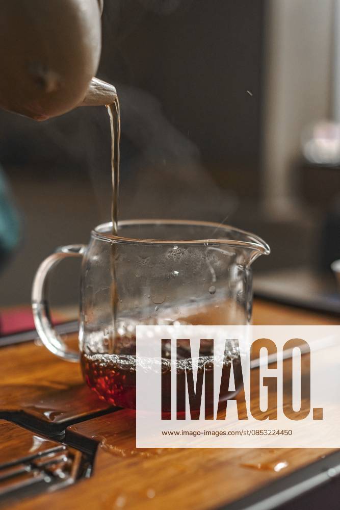 IMAGO Creative, Food, Trend, Iced Coffee Eine detaillierte Nahaufnahme von Tee, der vorsichtig in eine Glaskanne gegossen wird, um die Essenz des Brühens effektiv einzufangen A detailed close-up of tea carefully poured into a glass jug to effectively capture the essence of the brew