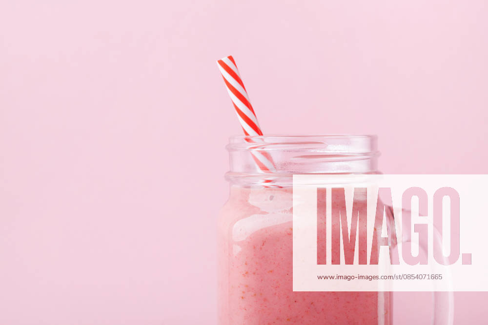 Frischer Erdbeer-Smoothie oder -Milchshake in einem Einmachglas vor einem pastellrosa Hintergrund. Gesunde Ernährung zum Frühstück und als Snack. Fresh strawberry smoothie or milkshake in mason jar on pink pastel background. Healthy food for breakfast and snack. (License=RF)