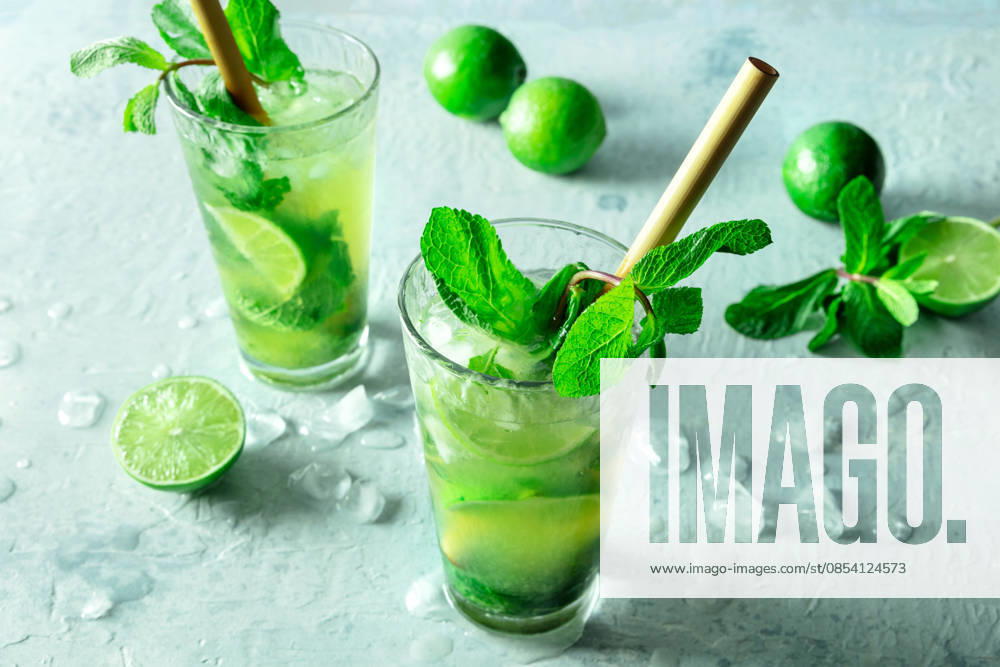 Mojito, Sommercocktail mit Minze und Eis, mit frischen Limetten, mit einem Strohhalm Mojito, summer cocktail with mint and ice, with fresh limes, with a bamboo straw (License=RF)