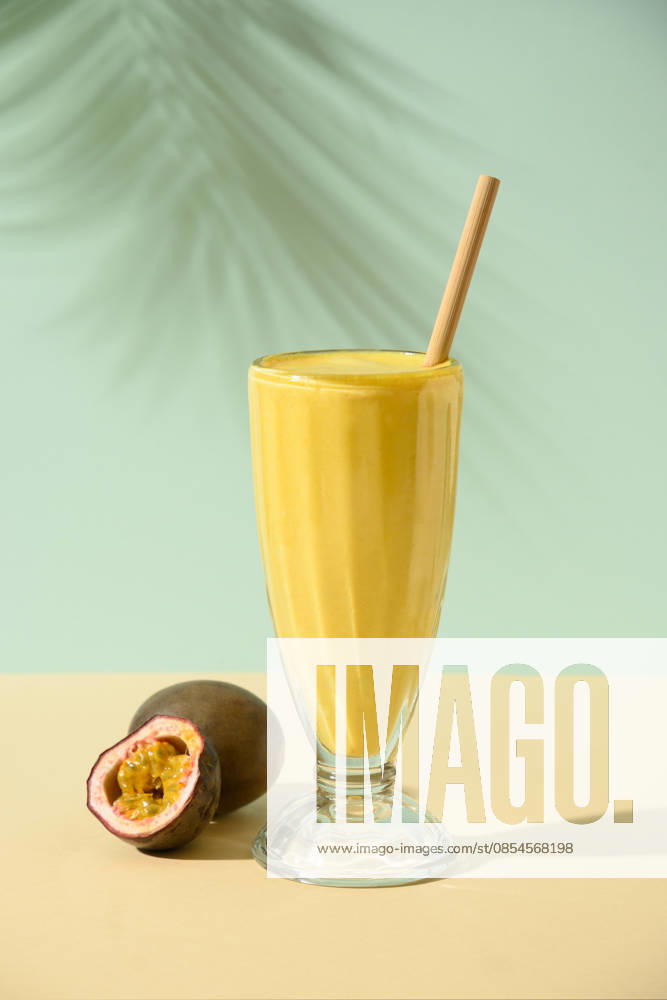 Indisches Mango- oder Kurkuma-Lassi auf blauem Hintergrund Passion Fruit Lassi on blue background with summer shadow. Vertical format. Indian healthy beverage lassi made of yogurt, water, spices, fruits and ice. (License=RF)
