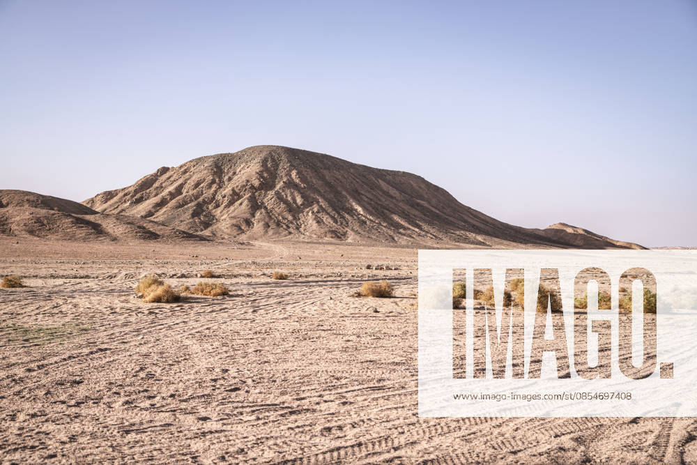 Marsa alam, egypt 21 april 2026: arid desert landscape with sparse vegetation and clear blue sky, capturing the vastness of the eastern desert in marsa alam, egypt Arid desert landscape with rolling eastern desert mountains