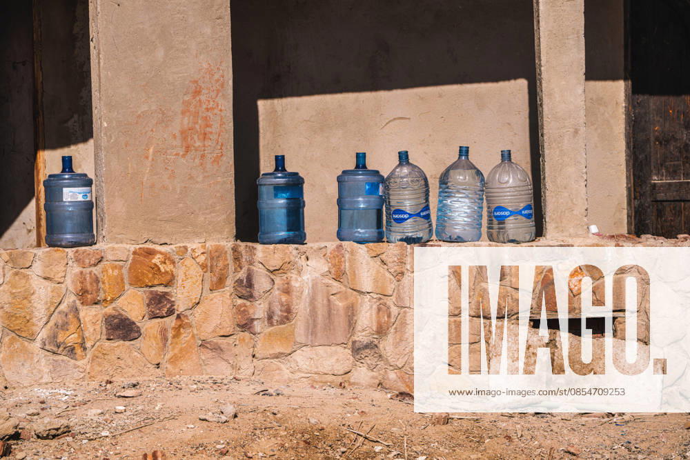 Marsa alam, egypt 21 april 2026: water bottles are lined up on a stone wall, representing hydration and resource management in a warm, dry desert region Water bottles stored in outdoor desert environment, marsa alam