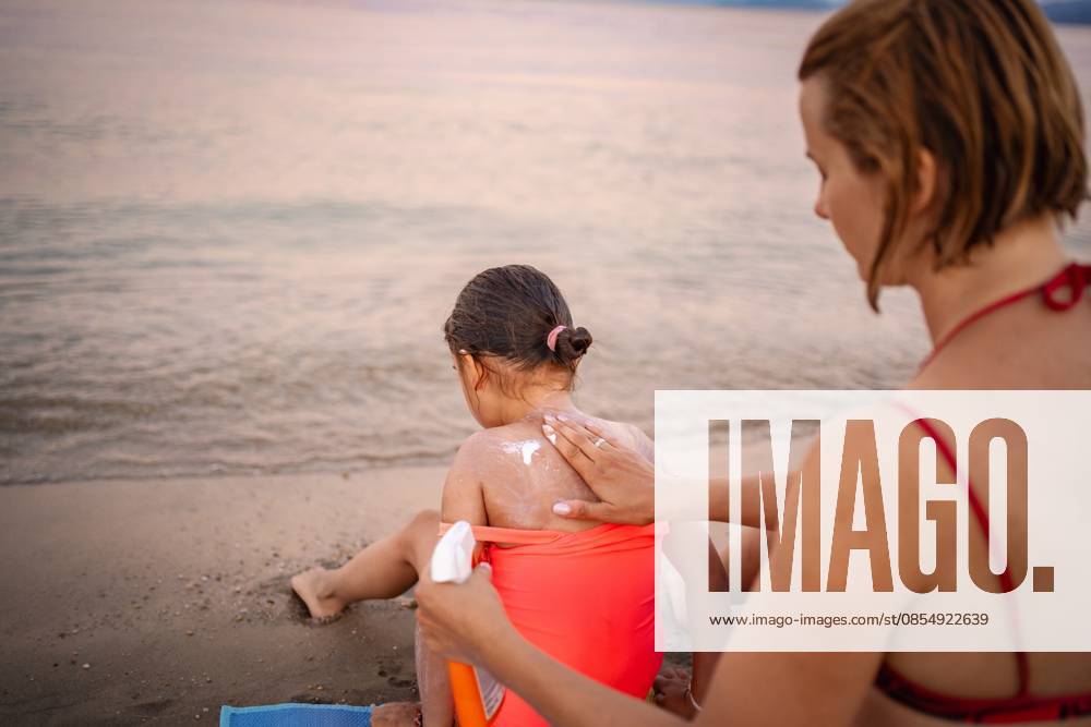 Einen sonnigen Tag in Griechenland am Strand genießen Applying sunscreen on a child at the shore of Greece (License=RF) ,model released, Symbolfoto