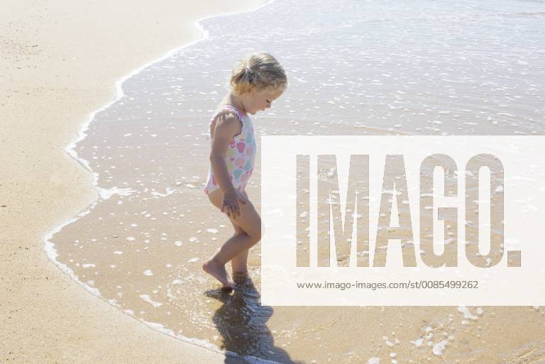 Little girl wading in the surf