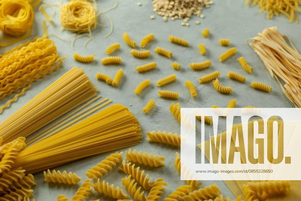Various types of uncooked pasta creating a patterns and textures on a light surface