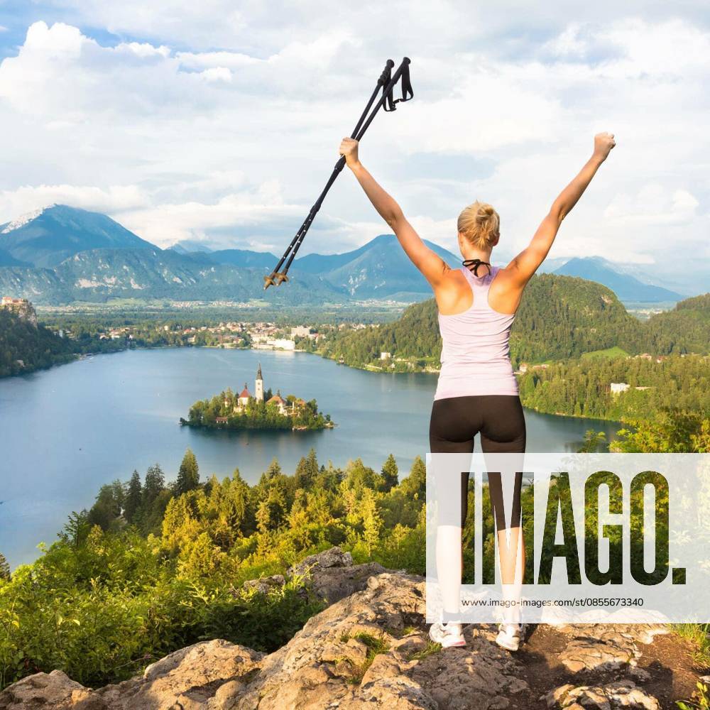 Made it! Young spoty active lady with hiking sticks and hands rised admiring beautiful nature around Bled Lake in Julian Alps, Slovenia. model released Symbolfoto