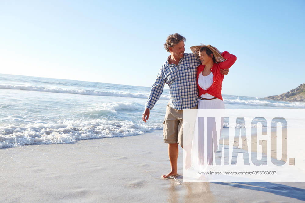 Living, loving and laughing. a mature couple enjoying a late afternoon walk on the beach (License=RF) ,model released, Symbolfoto