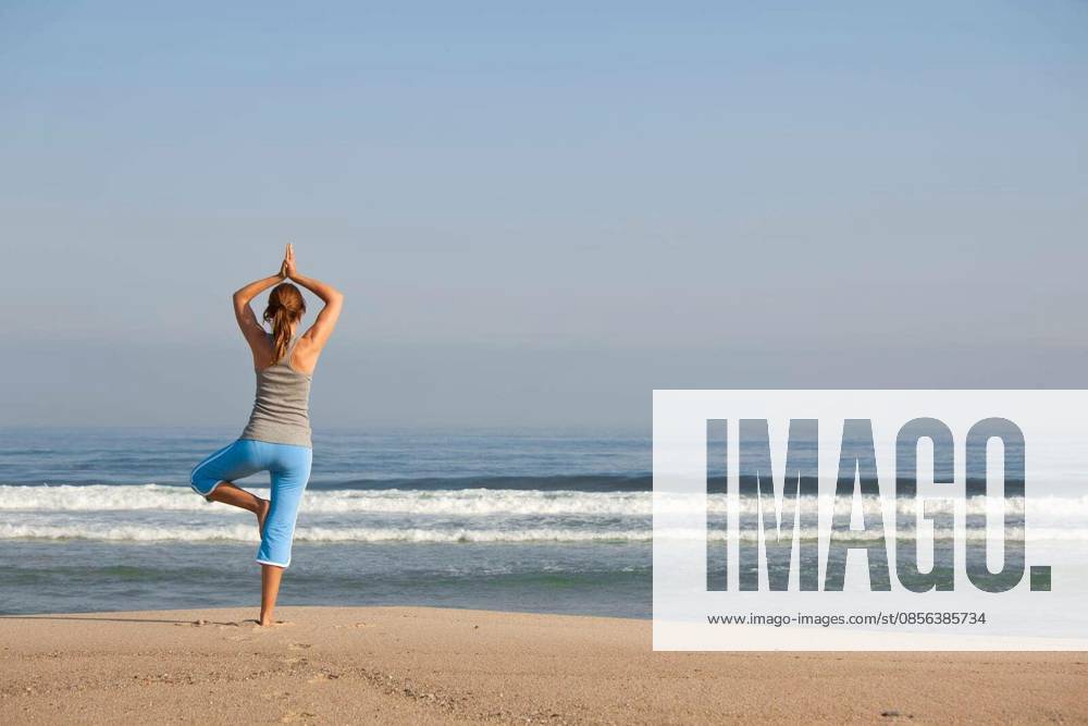 Beautiful young woman with arms open, relaxing on the beach model released Symbolfoto