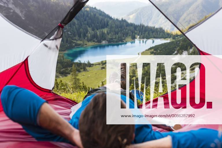Austria, Tyrol, Hiker relaxing in his tent in the mountains at Lake Seebensee model released Symbolfoto DIGF04785
