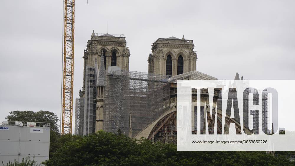 Eine historische Kathedrale, die restauriert wird, mit Gerüsten und einem Kran daneben. Notra Dame. Paris A historic cathedral undergoing restoration with scaffolding and a crane alongside. Notra Dame. Paris
