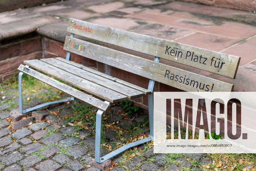 God Loves Diversity A wooden bench with the colorful engraved phrases *God Loves Diversity* and *No Place for Racism* from the *Dein Werk* initiative will be placed in front of St. Gallus Church in Ladenburg, Baden-Württemberg, on August 17, 2026, Germany. With such specially designed benches in public spaces, ch