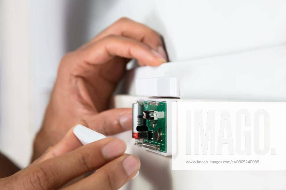 Close-up Of A Technician s Hand Repairing Security System Door Sensor