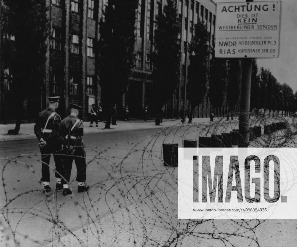British Besiege Communist Radio Station Two British military policemen patrol inside a barbed wire cordon which was thrown round the Russian-operated radio Berlin in the British sector of the city early morning, June 3. German police are on guard in the background. This action by the British is a counter-move after communists seized hamlets on the borders of the city. For years the communists have been broadcasting anti-western Propaganda from this station. June 3, 1952. (Photo by Associated Press Photo).