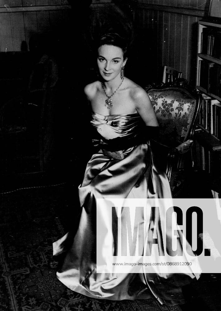 Joan in Pale Gold -- Actress Joan Greenwood will wear this pale gold gown for her presentation to the Royal Party at the Royal Film Performance on Monday. It has a tiny pleated bodice and a very full skirt. With it she wears on ostrich feathered headdress. October 25, 1952.
