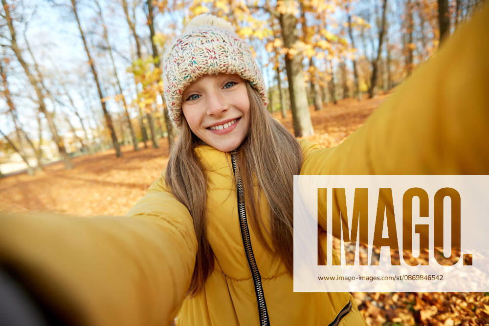 Glücklich mädchen taking selfie im herbst park saison und menschen konzept - glücklich mädchen taking selfie im herbst park (License=RF) ,model released, Symbolfoto
