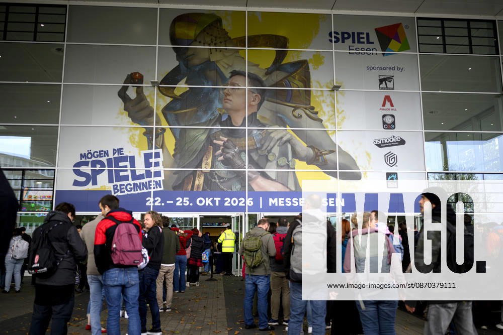 Visitors wait in front of the East Entrance; a rush of people; behind them, the SPIEL 26 logo; on October 22, 2026, at the SPIEL Essen trade show, held from October 22–25, 2026, in Essen, Germany, at the Grugahalle
