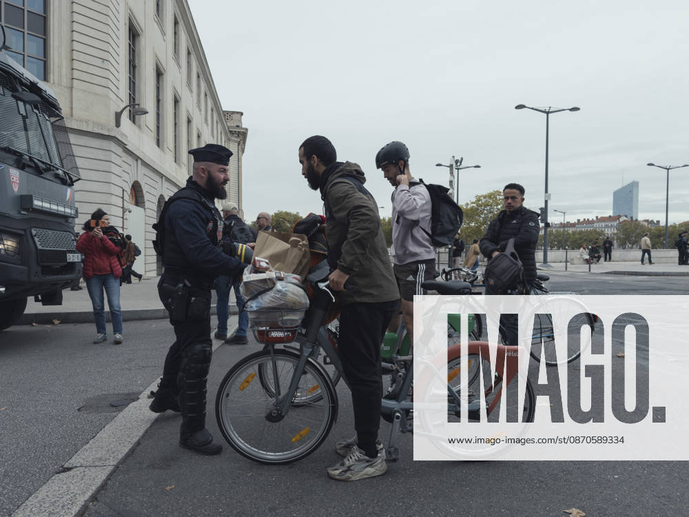 Lyon France Anti-Government Protest Cyclists are questioned by police officers beside a police vehicle in Lyon, France, on October 24, 2026. Police maintained a presence in Lyon as authorities restricted gatherings in parts of the city following unrest during demonstrations the previous weekend. Lyon Rhone Alpes France