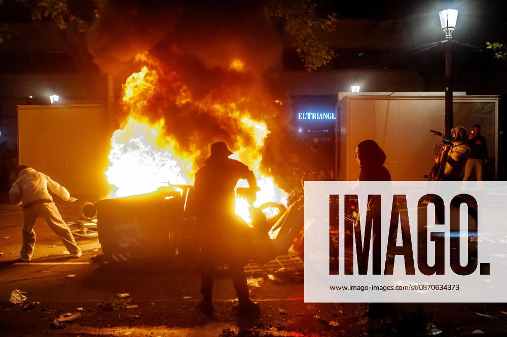 Demonstrators feed a burning barricade amid unrest in downtown Barcelona. Clashes between demonstrators and police, looting and widespread vandalism were reported across the city centre during the night. Barcelona Spain - ZUMAb137 20261024_fap_b137_010