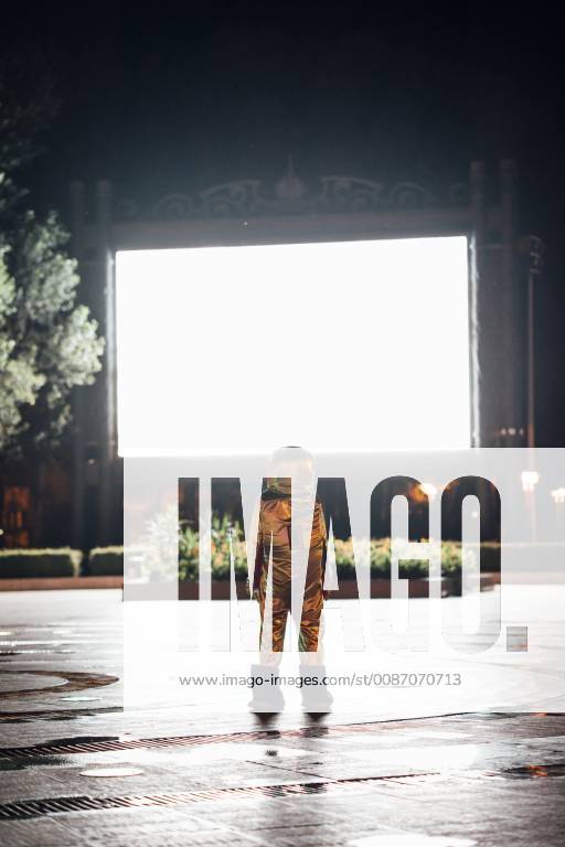 Spaceman on a square at night attracted by shining projection screen model released Symbolfoto VPIF00754