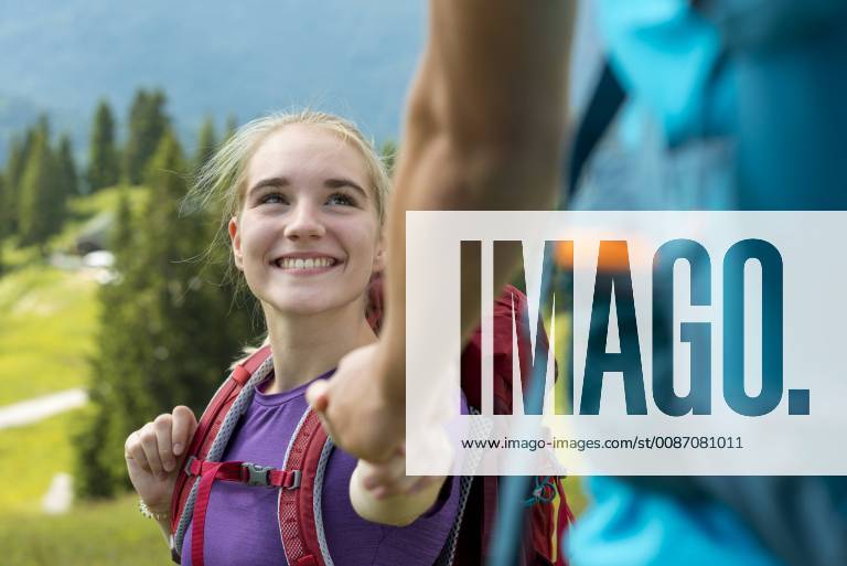 Germany, Bavaria, Brauneck near Lenggries, happy young woman hiking in alpine landscape holding hand of boyfriend model released Symbolfoto LBF02075