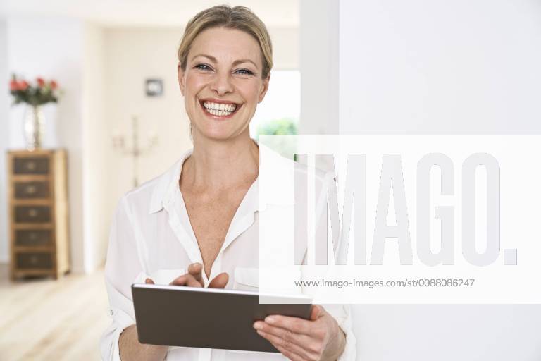 Portrait of happy woman using tablet at home model released Symbolfoto property released PDF01765